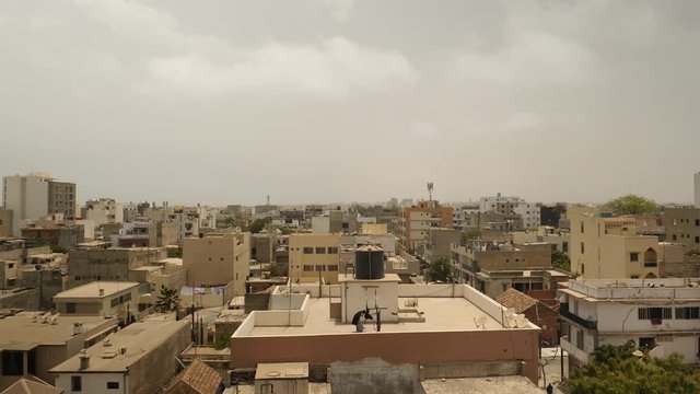 Dakar skyline with woman on rooftop, Senegal, Africa.