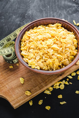 A plate with corn flakes on black wooden background. Healthy food