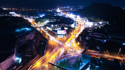At night. In december, 2017. The main intersection in Phuket town with many vehicles. this intersection has a tunnel to go under the intersection. and surround with department store and apartments.