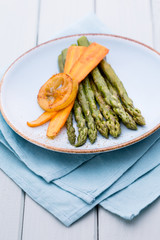 Fried asparagus with broccoli and lemon and carrot.
