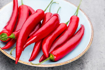 Chili cayenne pepper on grey background.