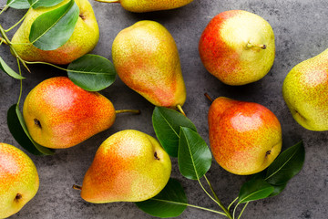 Fresh bio pear with leaves on the plate. Gray stone table.