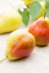 Fresh pears with leaves in a on wooden background.