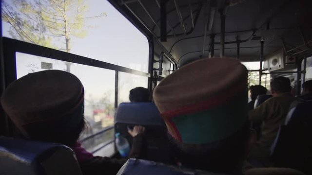 early morning travel, back view silhouette of passengers in indian bus driving in mountain