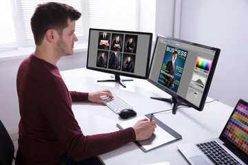 Designer Drawing On Graphic Tablet While Working On Computer