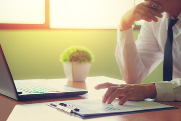 A dignified businesswoman analyzing information in the office and having morning sunshine.