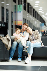 Young couple and their daughter sleeping in airport lounge before long flight