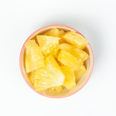 Pineapple in bowl on white background.