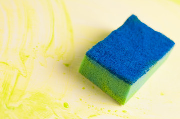 Blue messy sponge on dirty table with green mud