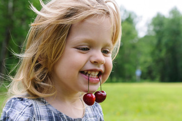little girl with a sweet cherry in her mouth