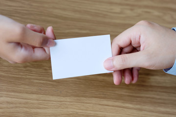 Obraz premium Businessman hand holding blank white business card with copy space for text, business mock up background concept