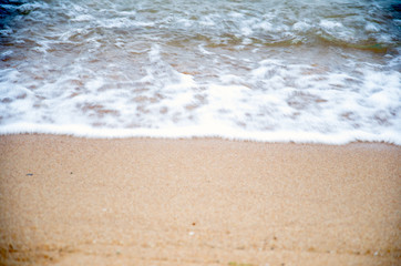 The beach with small waves and sand.