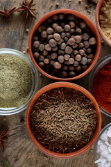 Spices in ceramic bowls on the top of wooden barrel, close-up, selective focus, vertical.