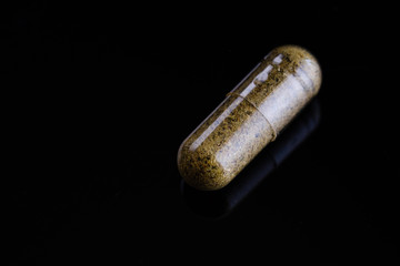 Biologically active food supplements in capsule on a dark background, macro