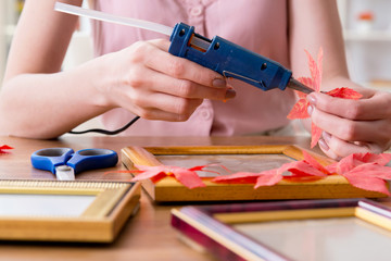 Woman decorating picture frame in scrapbooking concept