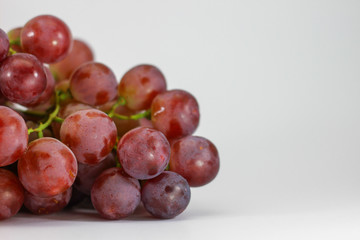 Red grapes on white background.