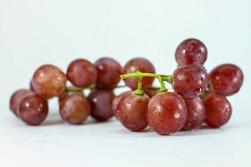 Red grapes on white background.