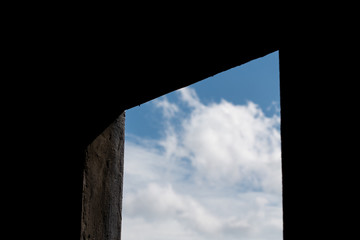 Silhouette window view with blue sky and white clouds . black space with sunlights at building
