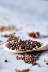 Fototapeta na wymiar Peppercorns in wooden spoon with clipping path on white textured background, close-up, selective focus.