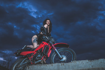 Sexy brunette biker girl sits on a motorcycle