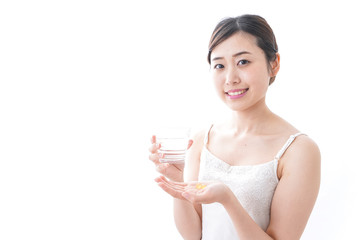 サプリメント・薬を飲む女性