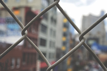 City view through a chain link fence
