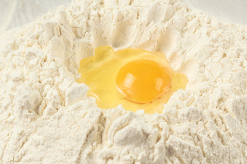 Egg in a pile of flour, cooking dough for noodles