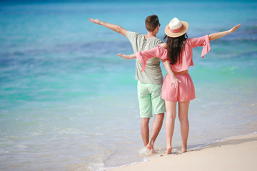 Young couple on white beach during summer vacation. Happy family enjoy their honeymoon