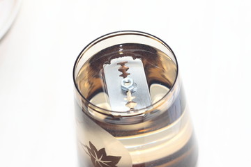 The blade floating on the surface of the water.  Amazingly, the metal does not sink in water. No trics, the nature laws only. Surface tension of the liquid. Plain water. Power of water.