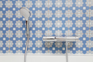 carrelage salle de bain bleu fleuri avec robinet et pommeau de douche 