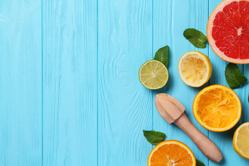 Squeezed citrus and juicer on a blue background. Juicing