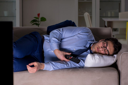 Businessman watching tv at night late