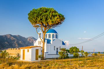 Church, Greece, Kos Island: warm sunset at a cozy little blue white church with red roof chapel in...
