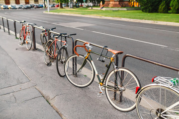 Fototapeta na wymiar Parked Bicycles On Sidewalk near city Street.