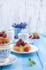 Small pies with berries, strawberries and cherries. Delicious sweet breakfast and fragrant coffee, on a blue wooden background. Flat lay, Copy space