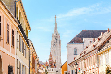 Fototapeta na wymiar Narrow city street leads to one of the best known and most popular sights of Budapest Matthias Church