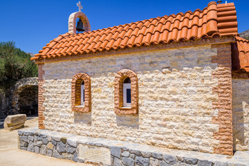 Church, Greece, Kos Island, Agios Theologos: old cozy little orange church with red roof chapel in traditional colors which perched on the greeksy sea next to a small tree over the barren mountains