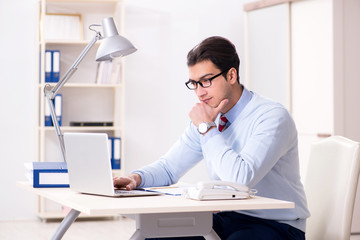 Fototapeta premium Young handsome businessman employee working in office at desk