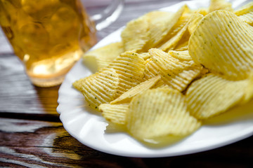 Potato chips and beer on a wooden table 
