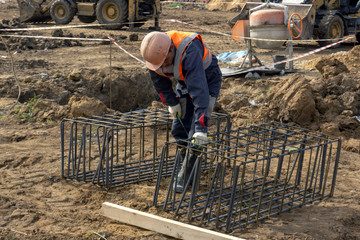 workers at the construction site make a framework of reinforcement