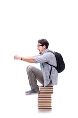 Young student sitting on top of book stack on white