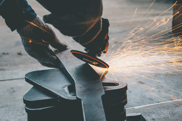 worker using  grinder steel in workshop and have  throwing sparks.