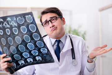 Young doctor looking at x-ray images in clinic
