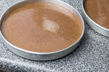 Cake pan with raw chocolate batter on kitchen counter top