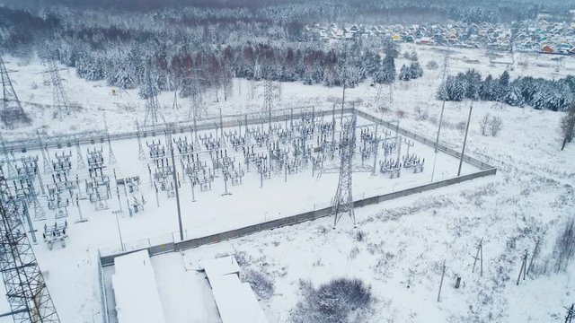 industrial buildings and insulators on station territory covered with snow