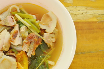 boiled grilled chicken with mushroom and tomato in tom yum spicy soup on bowl