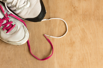 Man and woman fashion trendy trainers with lace heart on wooden background. Copy space. 