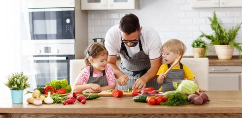 Abwaschbare Fototapete Kochen Vater mit Kindern, die Gemüsesalat vorbereiten