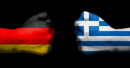 Flags of Germany and Greece painted on two clenched fists facing each other on black...