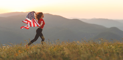 happy woman with flag of united states enjoying the sunset on nature
